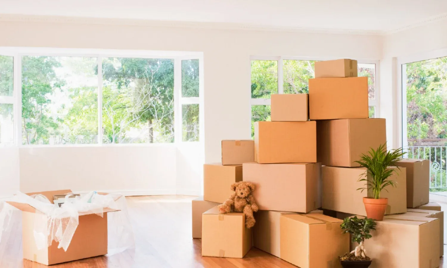 A stack of moving boxes sitting in an empty living room