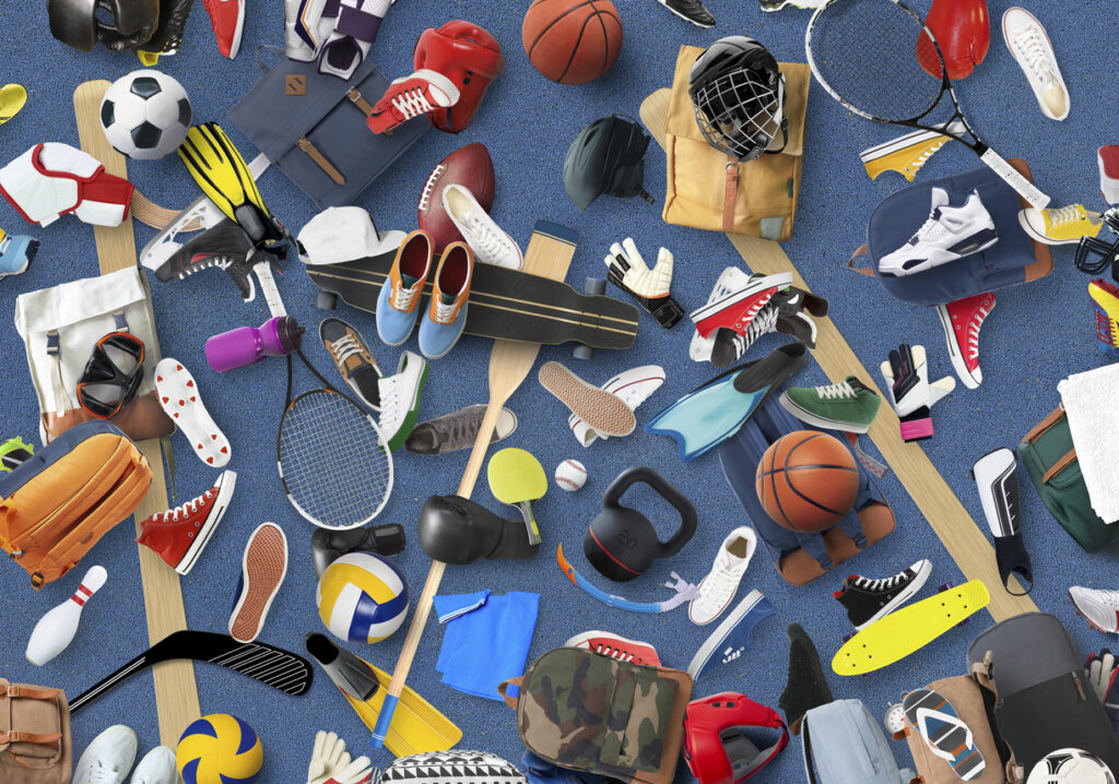An assortment of sports equipment spread across a blue floor.