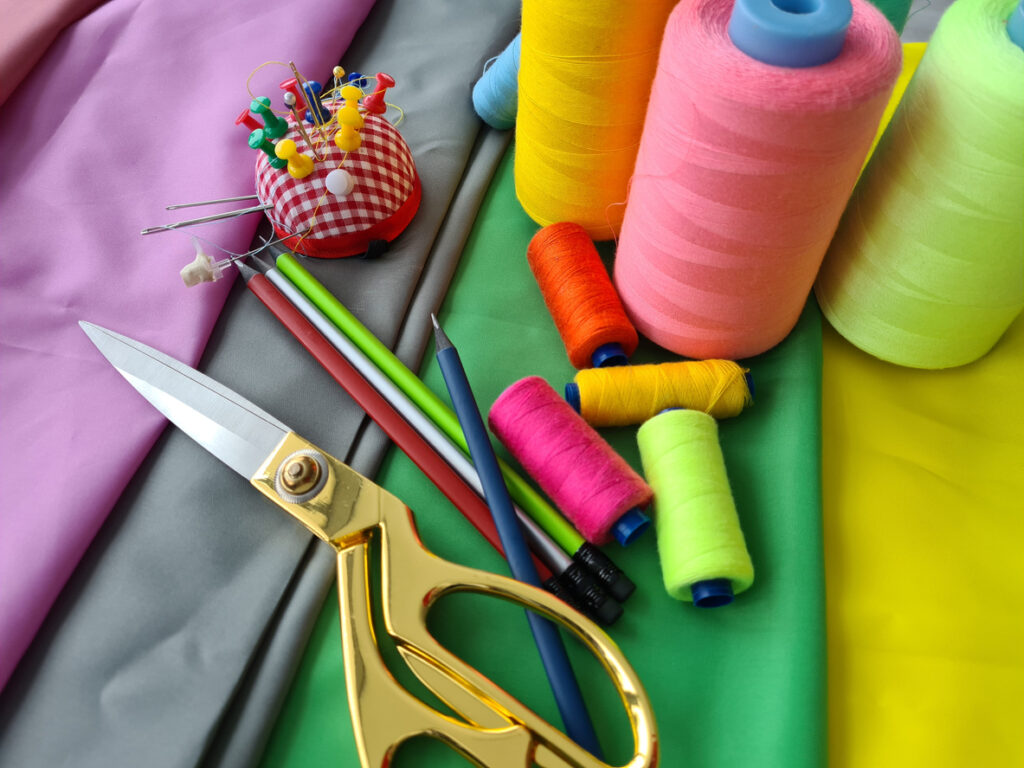 Several arts and crafts supplies spread across multiple colored fabrics ready for use.
